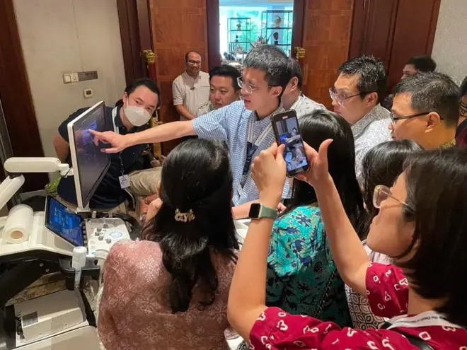 蘇炯睿醫師於國際工作坊進行超音波實作教學，多位醫師圍在超音波儀器前